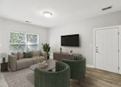 Thumbnail 3 of 26 - A living room with a grey couch, a green armchair, and a television mounted on the wall.