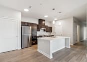 Thumbnail 32 of 36 - A modern kitchen with a white island and stainless steel appliances.