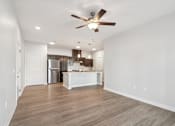 Thumbnail 30 of 36 - A spacious kitchen with a white island and wooden flooring.