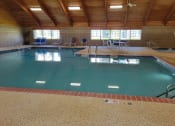 Thumbnail 52 of 58 - a large indoor swimming pool with chairs on the side