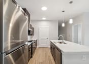 Thumbnail 5 of 36 - A modern kitchen with stainless steel appliances and wooden floors.