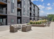 Thumbnail 44 of 56 - an outdoor patio with couches and chairs in front of a building