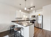 Thumbnail 1 of 56 - A modern kitchen with stainless steel appliances, a large island, and overhead lighting.