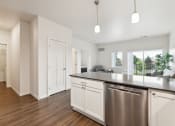 Thumbnail 7 of 56 - an open kitchen and living room with a large counter top and a stainless steel refrigerator