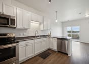 Thumbnail 4 of 56 - an empty kitchen with white cabinets and stainless steel appliances