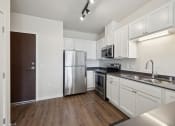 Thumbnail 3 of 56 - an empty kitchen with stainless steel appliances and white cabinetry