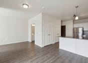 Thumbnail 20 of 56 - an empty living room and kitchen with white walls and wood flooring