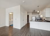 Thumbnail 21 of 56 - an open kitchen and living room with white walls and wood flooring