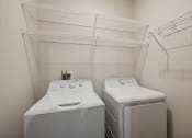 Thumbnail 28 of 56 - two washers and dryers in a laundry room with a shelf above them