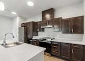Thumbnail 3 of 36 - A kitchen with brown cabinets and a white countertop.