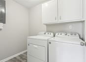 Thumbnail 18 of 28 - A white washer and dryer in a laundry room.