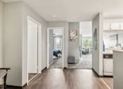Thumbnail 11 of 24 - A modern kitchen with a dining area and a bedroom visible through the open door.