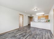 Thumbnail 1 of 31 - the living room and kitchen of an apartment with white walls and wood floors
