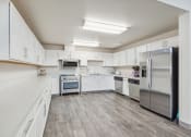 Thumbnail 29 of 31 - a large kitchen with white cabinets and stainless steel appliances