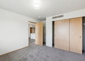 Thumbnail 12 of 31 - a living room with white walls and a door to a closet