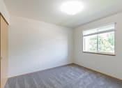 Thumbnail 10 of 31 - an empty living room with a window and carpet