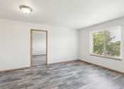 Thumbnail 7 of 31 - an empty living room with wood floors and a window