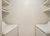 Thumbnail 20 of 24 - Two white washing machines in a laundry room.