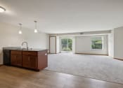 Thumbnail 21 of 58 - an empty living room and kitchen with wood flooring and a window