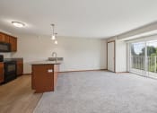 Thumbnail 28 of 58 - an empty living room with a kitchen and a large window
