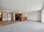Thumbnail 22 of 58 - an empty living room with a kitchen and a rug