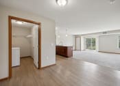 Thumbnail 30 of 58 - an open living room and kitchen with wood floors and white walls