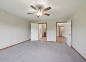 Thumbnail 27 of 58 - an empty living room with a ceiling fan and a carpet