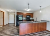 Thumbnail 19 of 58 - a kitchen with a granite counter top and a black refrigerator