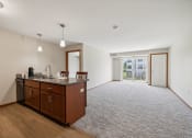 Thumbnail 12 of 58 - an empty living room with a kitchen and a door to a patio