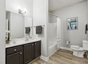 Thumbnail 10 of 26 - A bathroom with a toilet, sink, and mirror.