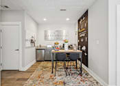 Thumbnail 22 of 26 - A kitchen area with a table and chairs in front of a chalkboard wall.