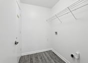 Thumbnail 10 of 20 - A white room with a door and a shelf.
