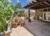 Thumbnail 15 of 39 - A patio with a table and chairs under a roof.