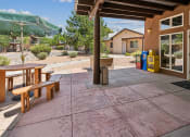 Thumbnail 6 of 39 - the back patio of a house with a picnic table and a table umbrella