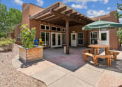 Thumbnail 8 of 39 - A patio area with a table and chairs under a pergola.