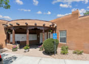 Thumbnail 9 of 39 - an orange building with a parking lot and a blue sign