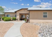 Thumbnail 3 of 39 - A house with a gravel driveway and a paved walkway leading to the front door.