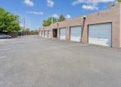 Thumbnail 12 of 39 - an empty parking lot in front of a building with garage doors