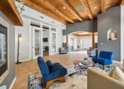 Thumbnail 20 of 39 - a living room with blue chairs and a rug and a fireplace
