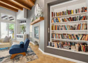 Thumbnail 29 of 39 - A living room with a blue chair and a bookshelf filled with books.