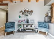 Thumbnail 30 of 39 - A living room with two blue chairs and a grey sofa.