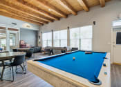 Thumbnail 38 of 39 - A pool table is in the middle of a room with a man sitting on a chair.