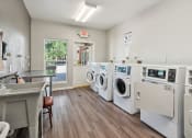 Thumbnail 26 of 39 - A laundromat with a row of washers and dryers.