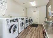 Thumbnail 19 of 39 - A laundromat with a row of washers and a counter.