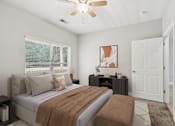 Thumbnail 8 of 26 - A bedroom with a bed, nightstand, and a ceiling fan.