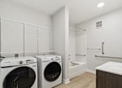 Thumbnail 33 of 36 - A laundry room with a washer and dryer.