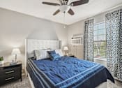 Thumbnail 13 of 24 - A bedroom with a large bed and a ceiling fan.