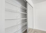 Thumbnail 9 of 20 - A white empty pantry with shelves and a carpeted floor.