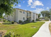 Thumbnail 13 of 20 - an apartment building with a sidewalk and grass outside of it