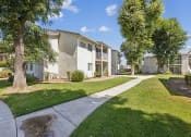 Thumbnail 8 of 20 - a tree lined sidewalk in front of an apartment building